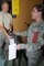 SSgt. Ashley Schofield is handed chemical overboots while processing through a simulated deployment mobility line as part of the weekend's Double Whammy Exercise. (U.S. Air Force photo by SrA Lillian Harnden)