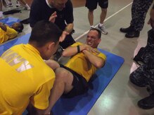 Chief Petty Officer selectee MM1 Christopher Huggins crunches out another sit up during morning physical training at Joint Base Charleston - Weapons Station last week. Physical training is a key component of Chief Petty Officer Induction, the process of transitioning first class petty officers into chief petty officers. Besides ensuring the Navy's newest chiefs are physically fit, PT provides an opportunity for the chief selectees to work alongside seasoned CPOs to build teamwork and camaraderie. Huggins is assigned to the Naval Consolidated Brig Charleston. (U.S. Navy photo/Chief Petty Officer Ira Holmes) 

