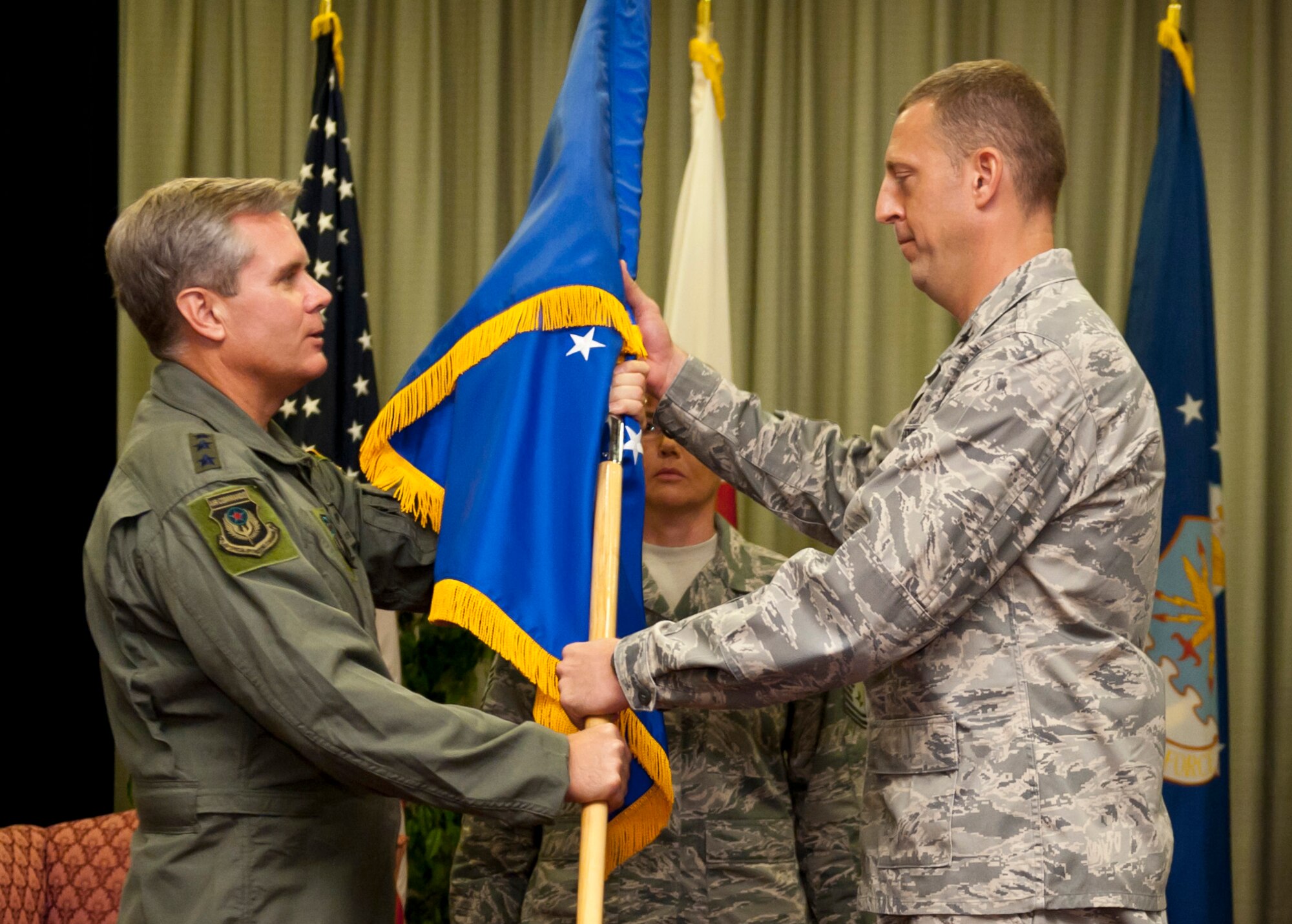 YOKOTA AIR BASE, Japan -- Lt. Gen. Eric Fiel (left), Air Force Special Operations Command commander, passes the 353rd Special Operations Group guidon to Col. Brad Sullivan, the new 353rd Special Operations Group commander during a change of command ceremony here Aug. 5. The ceremony was held at the Officers' Club here two days after Airmen and aircraft evacuated Kadena Air Base for Typhoon Mufia. (U.S. Air Force photo by Staff Sgt. Sam Morse)