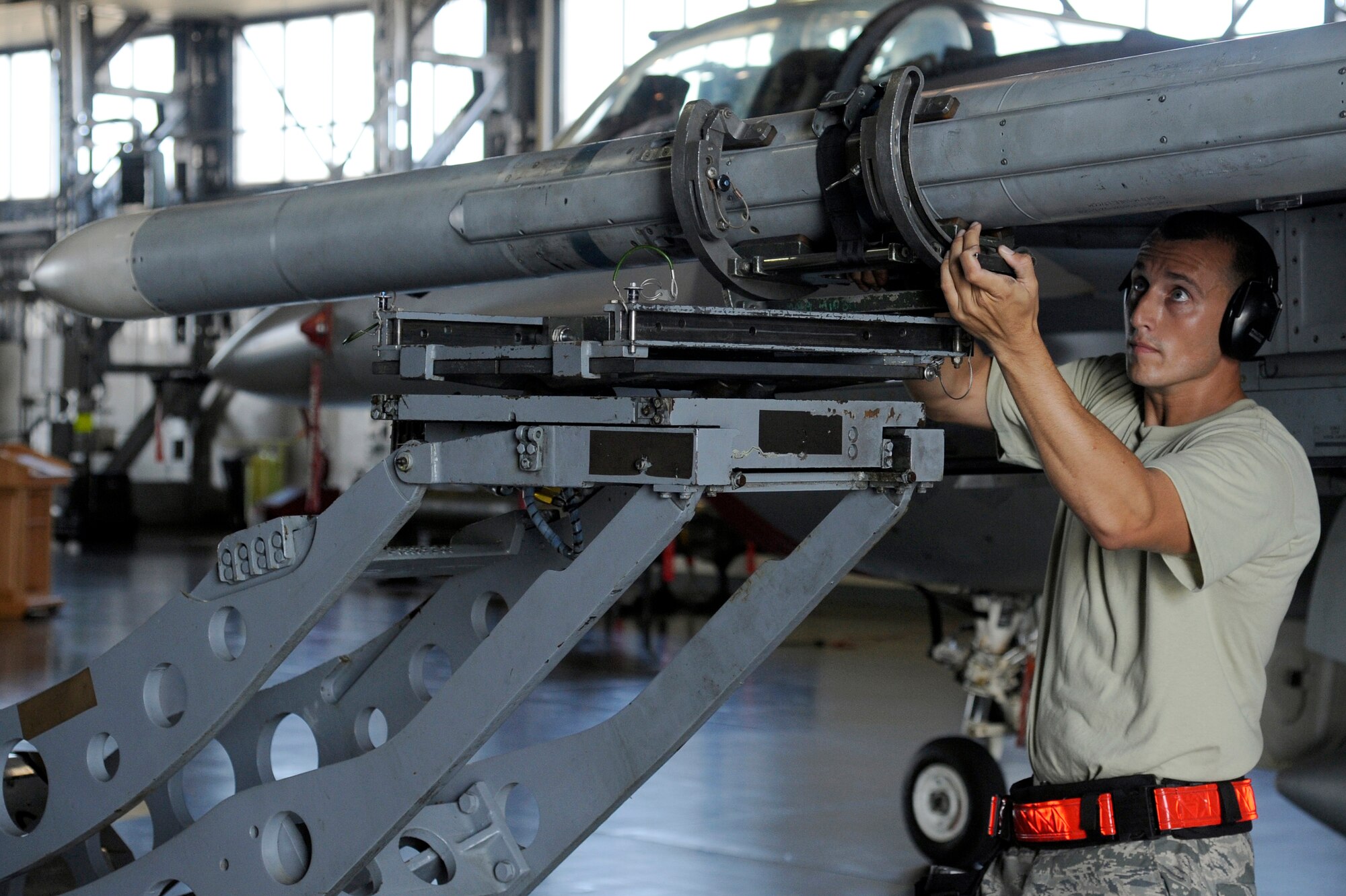 MISAWA AIR BASE, Japan -- Staff Sgt. Joshua Hollenbaugh, 13th Aircraft Maintenance Unit, guides an AIM-120 advanced medium-range air-to-air missile onto an F-16 Fighting Falcon during the load crew-of-the-quarter competition Aug. 5. The F-16 is capable of carrying six AIM-120 missiles at a time. (U.S. Air Force photo/Staff Sgt. Marie Brown)
