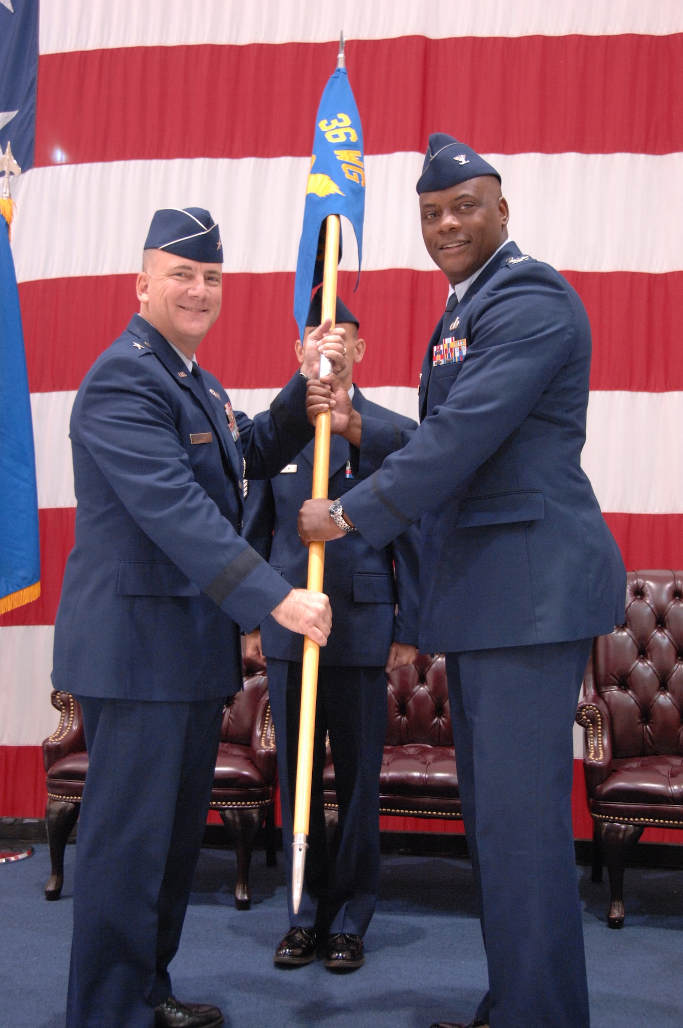 Brig. Gen. John Doucette (left), 36th Wing commander, passes the 36th Mission Support Group guidon to Col. Dwayne Thomas, newly appointed 36 MSG commander, during a change of command ceremony here July 12.(U.S. Air Force photo/ Senior Airman Carlin Leslie)

