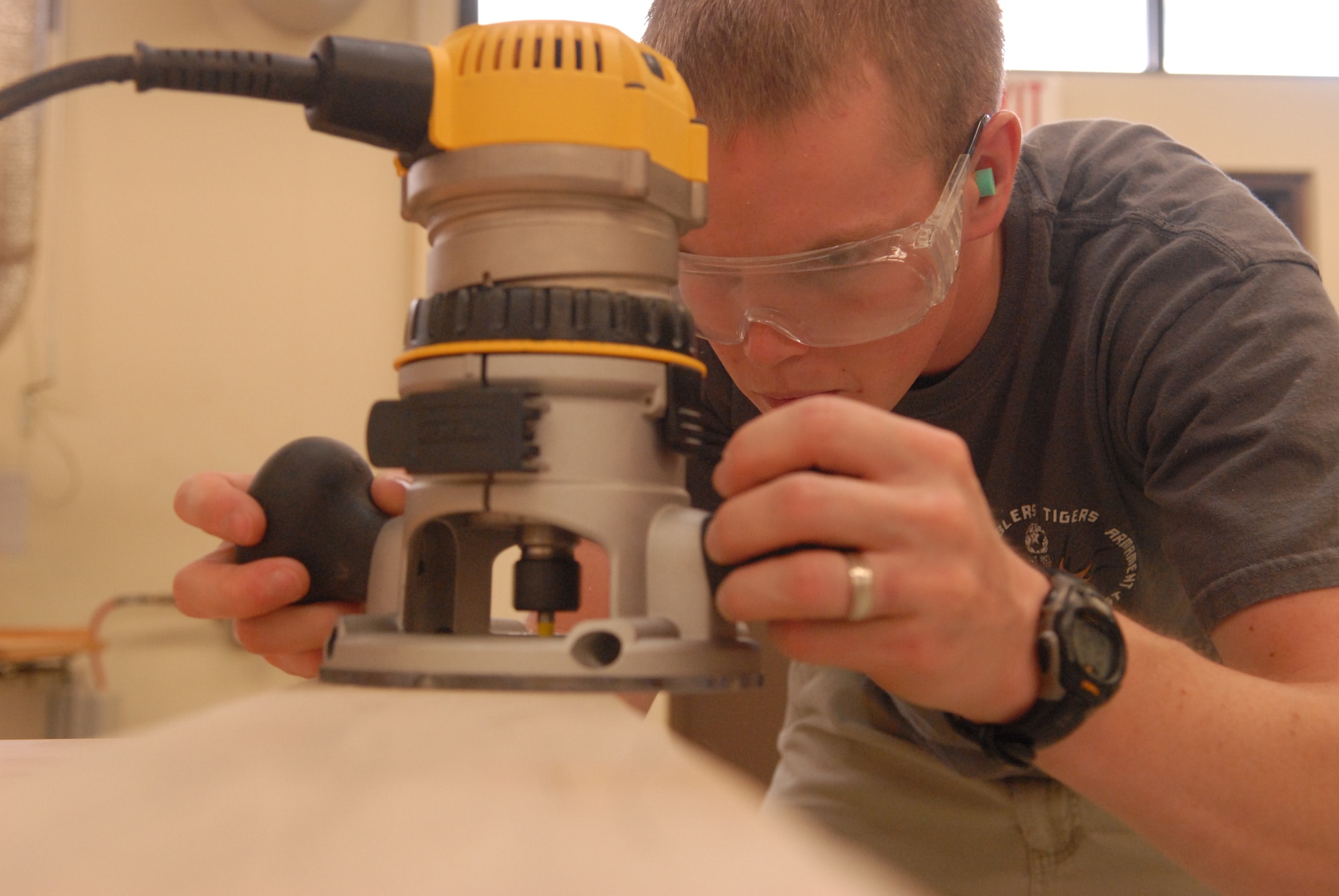 KUNSAN AIR BASE, Republic of Korea -- Senior Airman Philip Bennett, 8th Maintenance Operations Squadron weapons standardization load crew member, uses a router at the Arts and Crafts Center wood shop here Aug. 3. Bennett started with the wood shop’s safety course, a requirement for anyone wanting to use the assorted saws, planers and sanders. Following that, he got to work right away. He’s spent time before and after work and over the weekend to turn a pile of wood into a team-building tool for his squadron -- a dartboard case. (U.S. Air Force photo/Master Sgt. Sonny Cohrs)