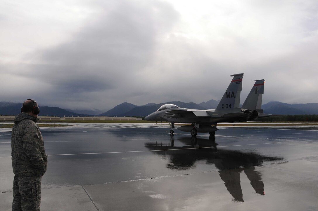Lieutenant Colonel Bigelow watches as an F-15D from the 104th Fighter Wing, Mass Air National Guard, taxis down the flight line prior to take-off while deployed to Joint Base Elmendorf-Richardson, Alaska. (U.S. Air Force Photo by: Technical Sergeant, Anthony M. Mutti)