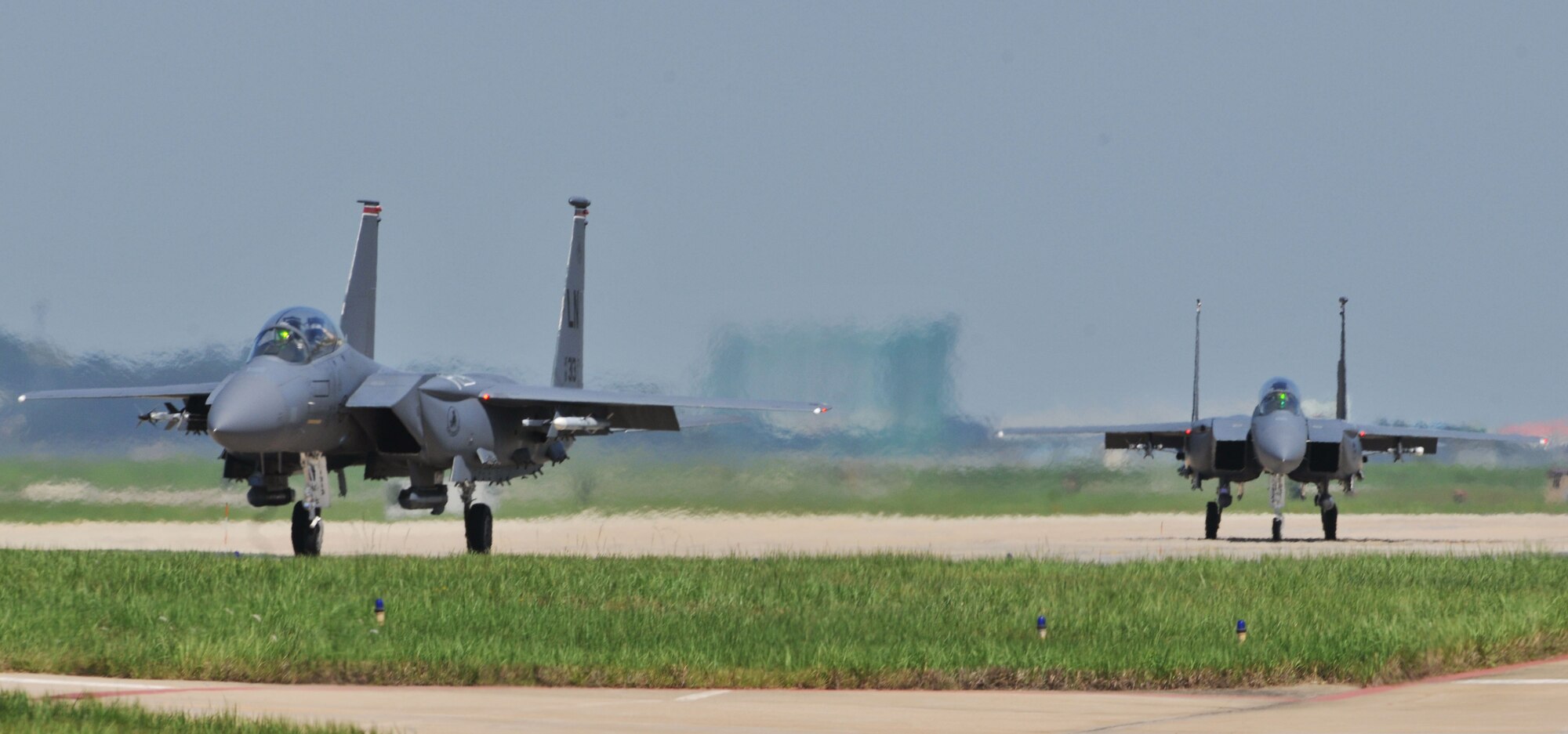KUNSAN AIR BASE, Republic of Korea -- Two F-15E Eagle Strike taxi down the flightline here Aug. 5. Army and Air Force units teamed up for a joint training exercise at Jikdo Island, firing AGM-114 Hellfire missiles, rockets and 30mm munitions at the range. (U.S. Air Force photo/Senior Airman Brittany Y. Bateman)
