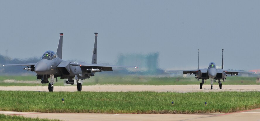 KUNSAN AIR BASE, Republic of Korea -- Two F-15E Eagle Strike taxi down the flightline here Aug. 5. Army and Air Force units teamed up for a joint training exercise at Jikdo Island, firing AGM-114 Hellfire missiles, rockets and 30mm munitions at the range. (U.S. Air Force photo/Senior Airman Brittany Y. Bateman)