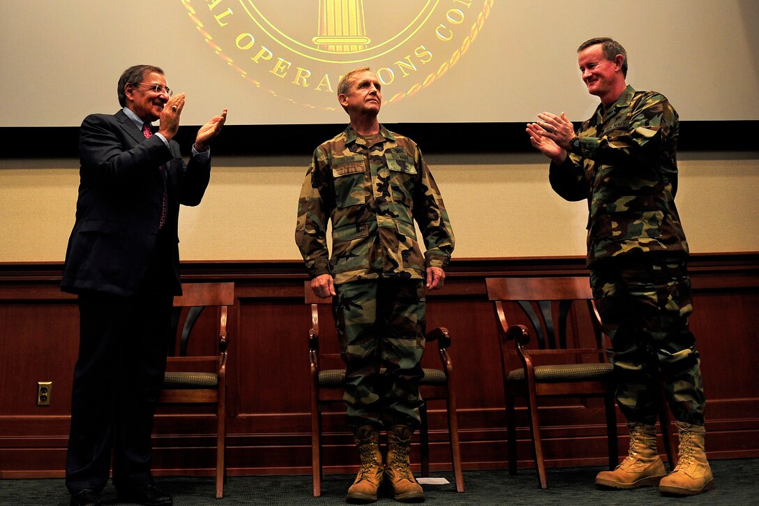 Defense Secretary Leon E. Panetta, left, and Navy Adm. William H. McRaven, right, applaud Navy Adm. Eric T. Olson during the U.S. Special Operations Command change of command ceremony held at MacDill Air Force Base, Fla., Aug. 8, 2011. Olson relinquished command to McRaven during the ceremony.
