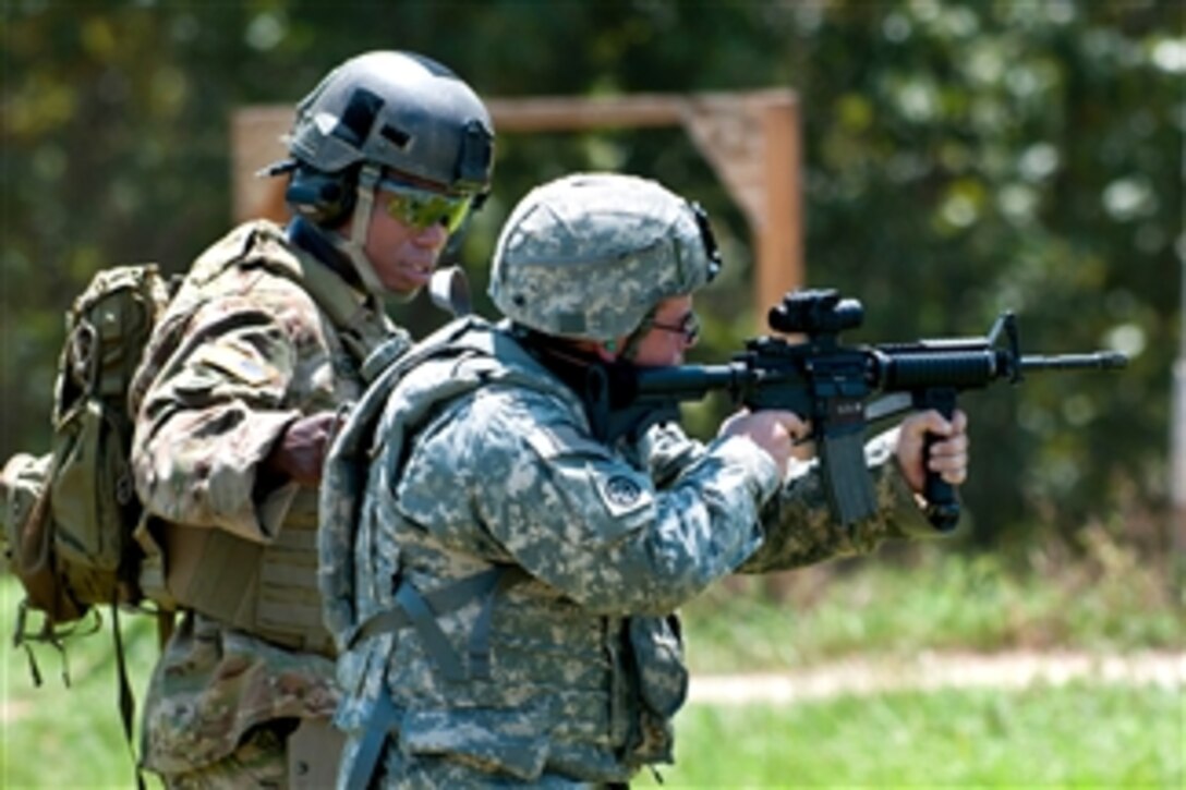 An Army instructor works with an Army paratrooper on close quarter marksmanship during field training at Fort Bragg, N.C., on Aug 1, 2011.  The paratrooper is assigned to the 82nd Airborne Division's 1st Brigade Combat Team.  The instructor is assigned to the 3rd Special Forces Group.  