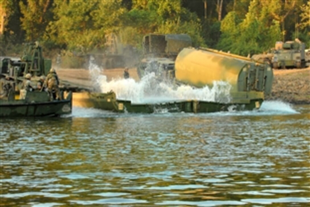 Army soldiers launch and position bridge bay sections during River Assault 2011 on Fort Chaffee, Ark., July 27, 2011. The soldiers are assigned to the Reserves 652nd Multi-Role Bridge Company, Ellsworth, Wis,. River Assault 2011 is a two-week extended combat training exercise that utilizes the technical skills of various engineer units to construct a floating improved ribbon bridge across the Arkansas River.