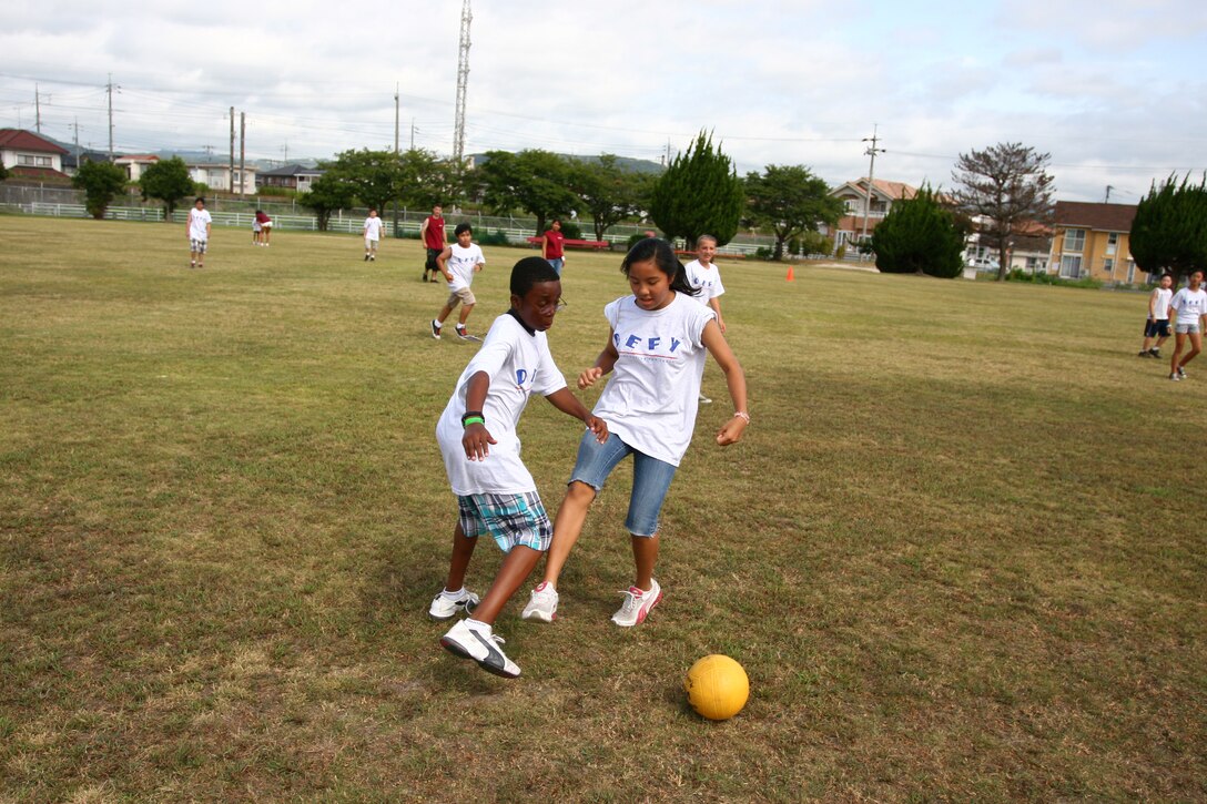 Mahlik Francis, 10, and Alexis Flores, 12, play soccer in a DEFY game Aug. 9. The children get exercise and eat healthy to show they can make the right choices.