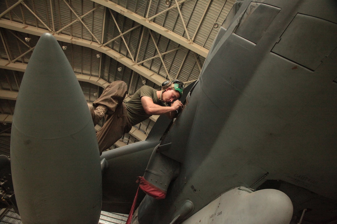 Lance Cpl. Benjamin Johnson, a Marine Attack Squadron 513 avionics technician and Blanchard, Okla., native, puts back a fuel level amplifier on one of the squadron’s AV-8B Harriers in the squadron’s hangar at Kandahar Airfield, Afghanistan, Aug. 9.