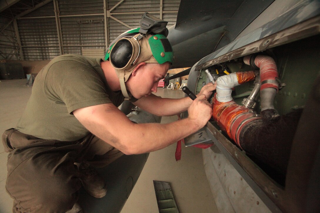 Lance Cpl. Benjamin Johnson, a Marine Attack Squadron 513 avionics technician and Blanchard, Okla., native, puts back a fuel level amplifier on one of the squadron’s AV-8B Harriers in the squadron’s hangar at Kandahar Airfield, Afghanistan, Aug. 9.
