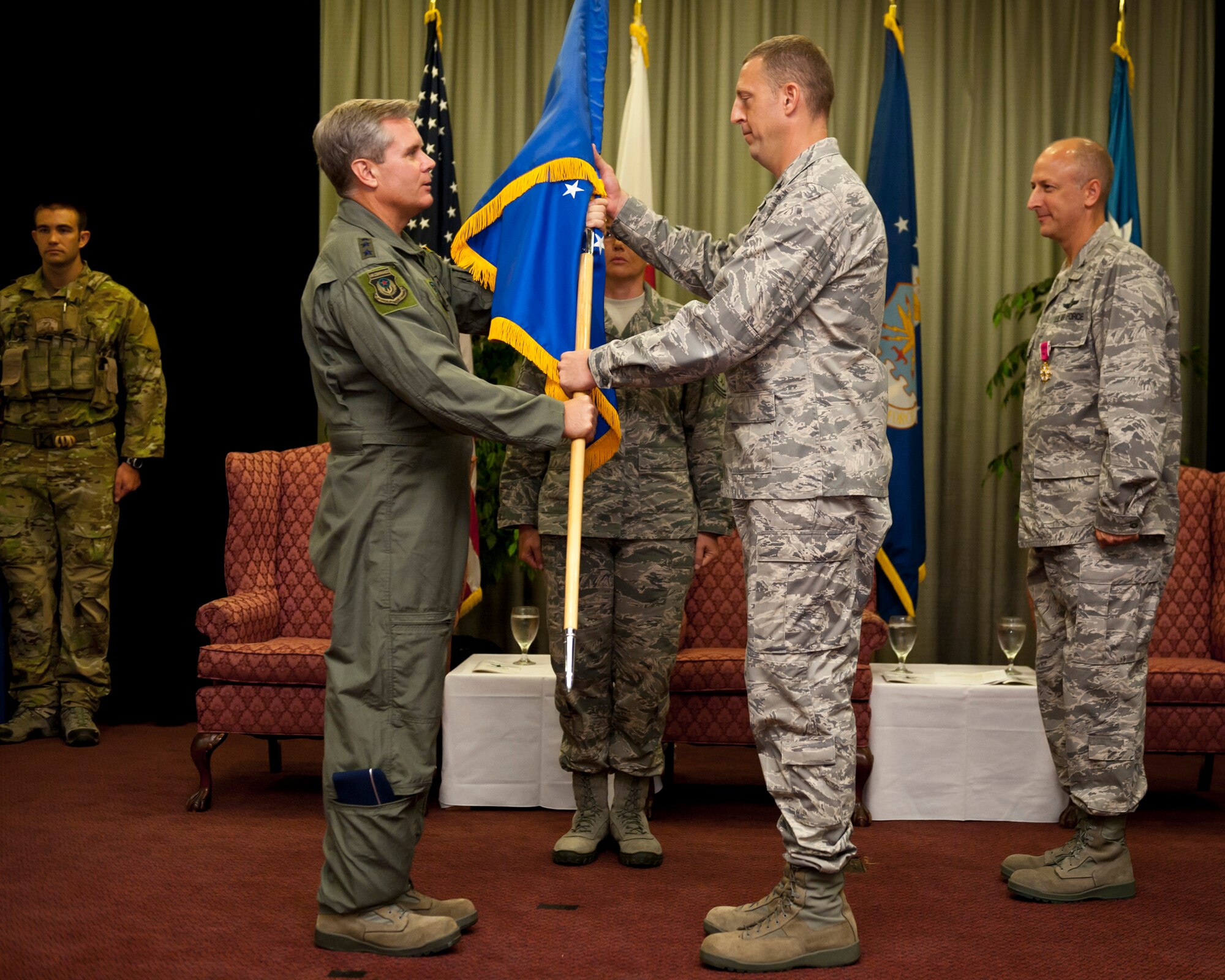 YOKOTA AIR BASE, Japan -- Lt. Gen. Eric Fiel (left), Air Force Special Operations Command commander, passes the 353rd Special Operations Group guidon to Col. Brad Sullivan, 353rd Special Operations Group commander, during a change of command ceremony at Yokota Air Base, Japan, Aug. 5, 2011. The ceremony was held at Yokota two days after Airmen and aircraft evacuated Kadena Air Base due to Typhoon Mufia. (U.S. Air Force photo/Staff Sgt. Samuel Morse)