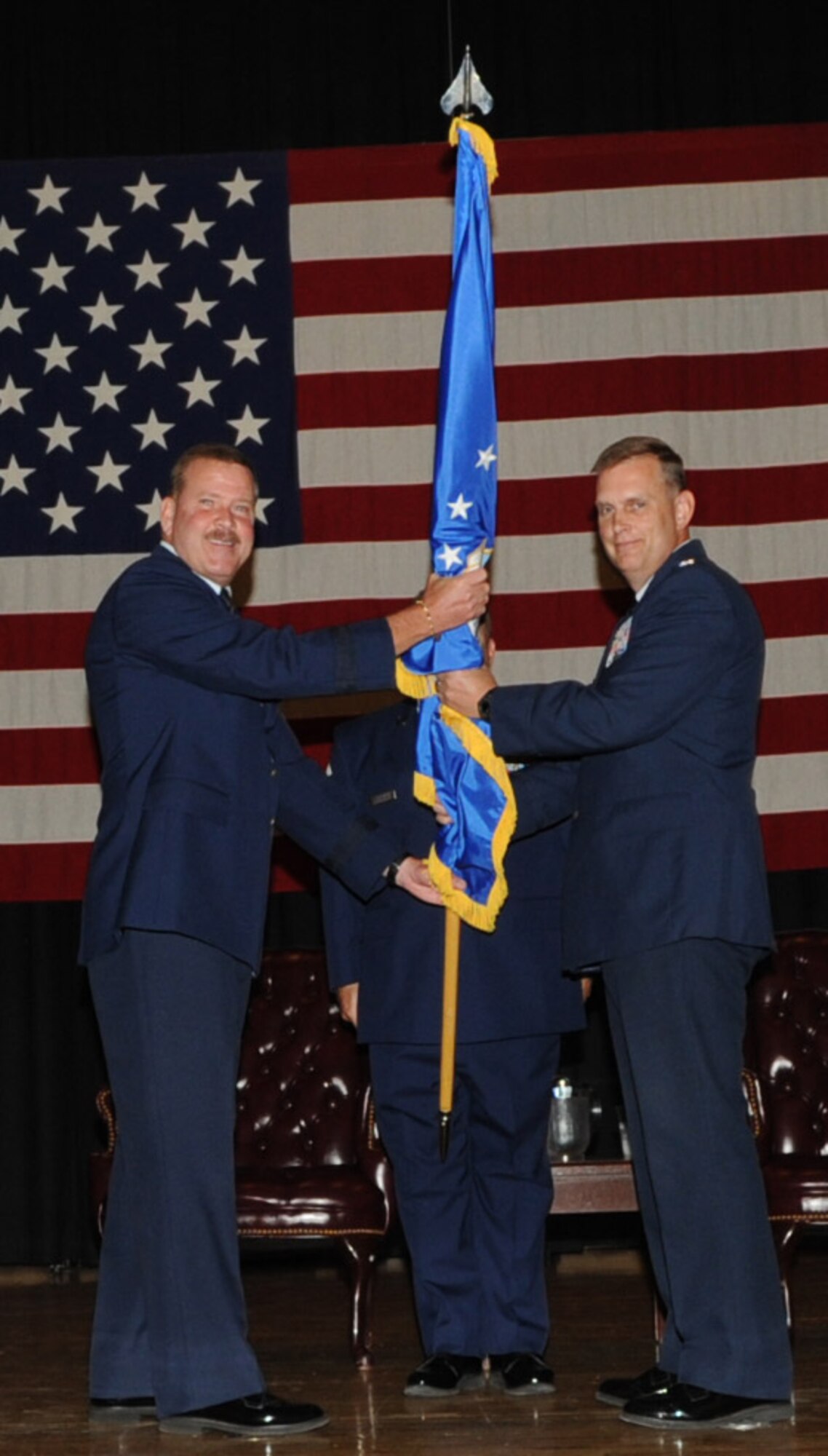 Brig. Gen. Mark A. Kyle, Commander, 4th Air Force, hands the 931st ARG colors to Col. William H. Mason during an assumption of command ceremony at McConnell AFB, Aug. 6.  Colonel Mason is the ninth commander of the 931st since the unit's reactivation at McConnell. (Official Air Force photo by Staff Sgt. Carrie Peasinger)