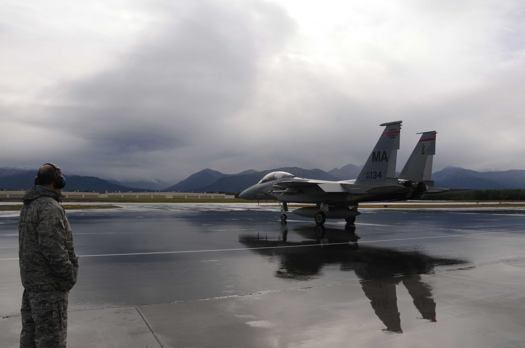 Lt. Col. Chris Bigelow observes as an F-15 Eagle from the Massachusetts Air National Guard’s 104th Fighter Wing taxis down the flight line Aug. 5, 2011, prior to take-off while deployed to Joint Base Elmendorf-Richardson, Alaska, for training. Bigelow is the commander of the 104th Maintenance Squadron.  (U.S. Air Force photo/Tech. Sgt. Anthony M. Mutti )
