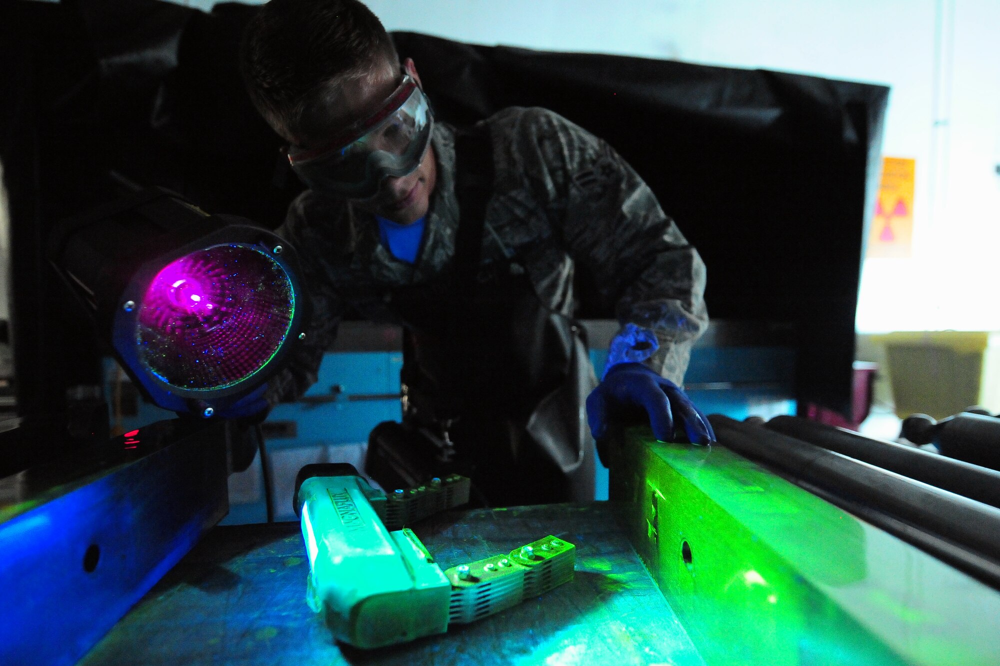 MINOT AIR FORCE BASE, N.D.  – Airman 1st Class Jarred Irick, 5th Maintenance Squadron non-destructive inspection apprentice, spray down parts of a B-52H Stratofortress and perform a magnetic particle inspection allowing inspectors to track internal cracks and discontinuities within the equipment, here Aug. 8. NDI is the examination of aerospace weapon systems components and support equipment for structural integrity using nondestructive inspection methods and fluid analysis. (U.S. Air Force Photo/ Senior Airman Jesse Lopez)