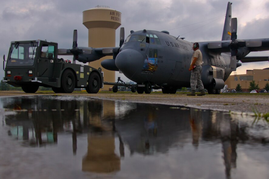 Members of the 911th Aircraft Maintenance Squadron tow a C-130 from its spot on the flightline to a hangar for maintenance, Aug. 9.  Aircraft undergo routine maintenance to ensure mission readiness. (U.S. Air Force Photo/Senior Airman Joshua J. Seybert)