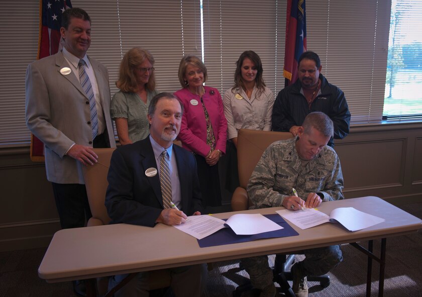 Staff from Wiregrass Technical College the 23rd Medical Group watch as U.S. Air Force Col. Mark Koppen, 23rd MDG commander, signs an agreement allowing  students to complete the clinical portion of their curriculum at Moody Air Force Base, Ga.,  Aug. 9, 2011, at WTC, Valdosta, Ga. Members of both parties spoke of the venture as a good way to build relations between the college and Moody. (U.S. Air Force by Airman 1st Class Joshua Green/Released)
