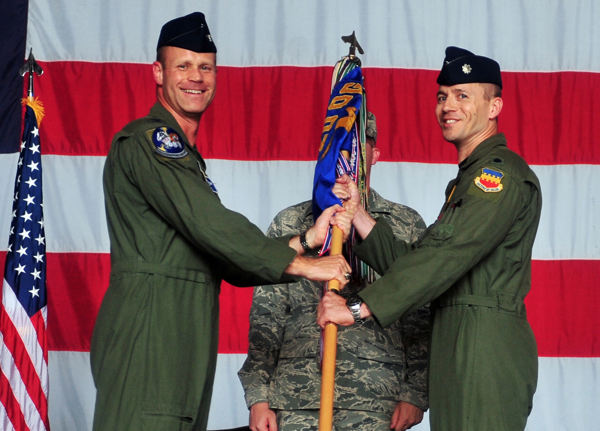 U.S. Air Force Col. James Sears, 20th Operations Group commander, presents the guide-on to the new 79th Fighter Squadron Commander Lt. Col. Jason Plourde during a change of command ceremony at Shaw Base Air Force, S.C., Aug. 5, 2011.The passing of the guide-on is a ceremonial representation of the previous commander handing over his responsibilities to the new commander. (U.S. Air Force photo by Airman 1st Class Ashley Gardner/ Released)