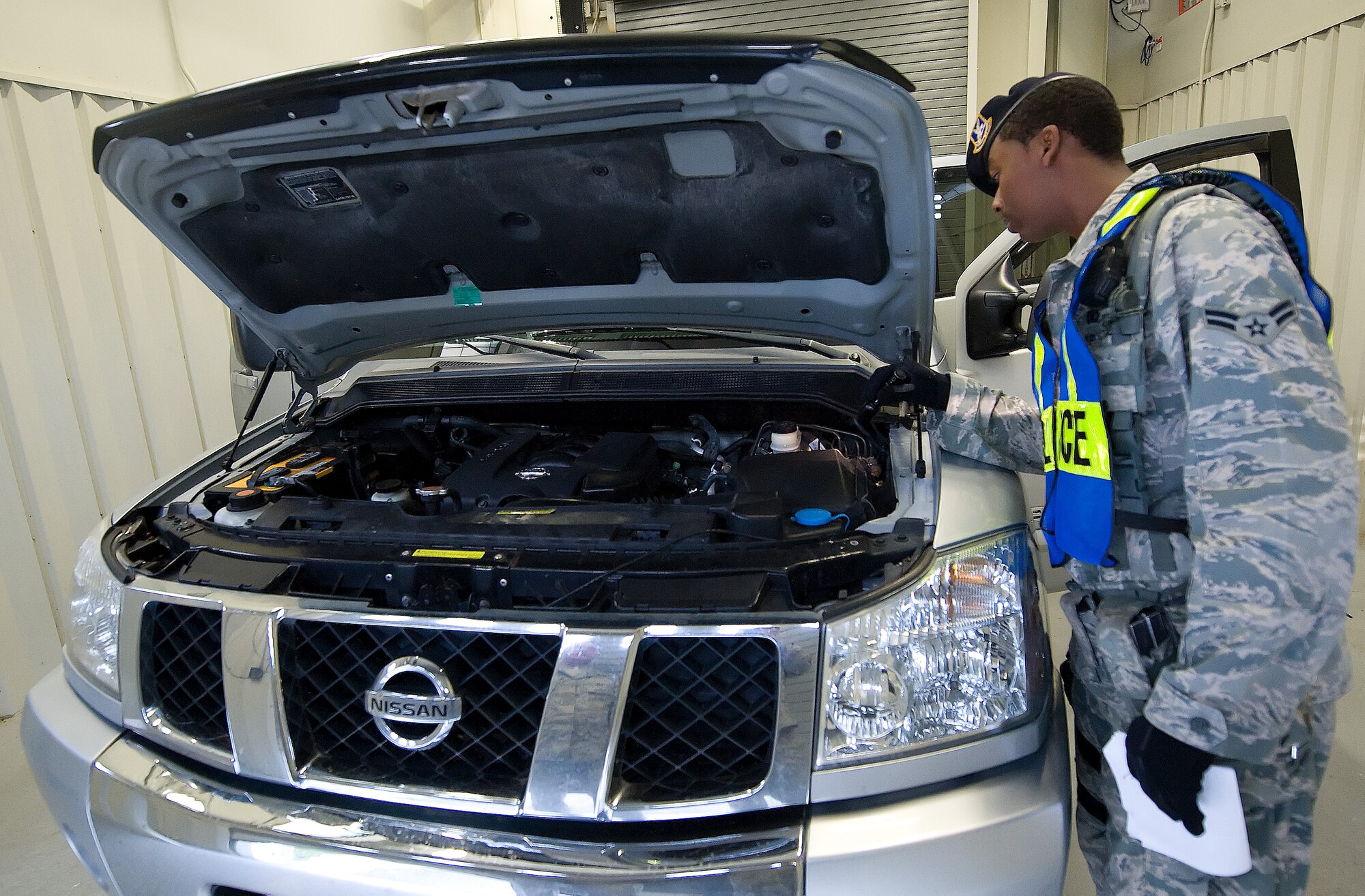 Airman 1st Class Moses McDonald, a patrolman with the 436th Security Forces Squadron, inspects a vehicle during a random antiterrorism measure Aug. 8, 2011, at Dover Air Force Base, Del. Patrolmen from the 436 SFS are responsible for security of the base as well as law enforcement. (U.S. Air Force photo by Airman 1st Class Jacob Morgan)