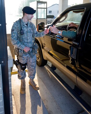 Senior Airman Brian Trueblood, a patrolman with the 436th Security Forces Squadron, checks identification of a driver coming through the North Gate Aug. 8, 2011, at Dover Air Force Base, Del. Patrolmen from the 436 SFS are responsible for security of the base as well as law enforcement. (U.S. Air Force photo by Airman 1st Class Jacob Morgan)