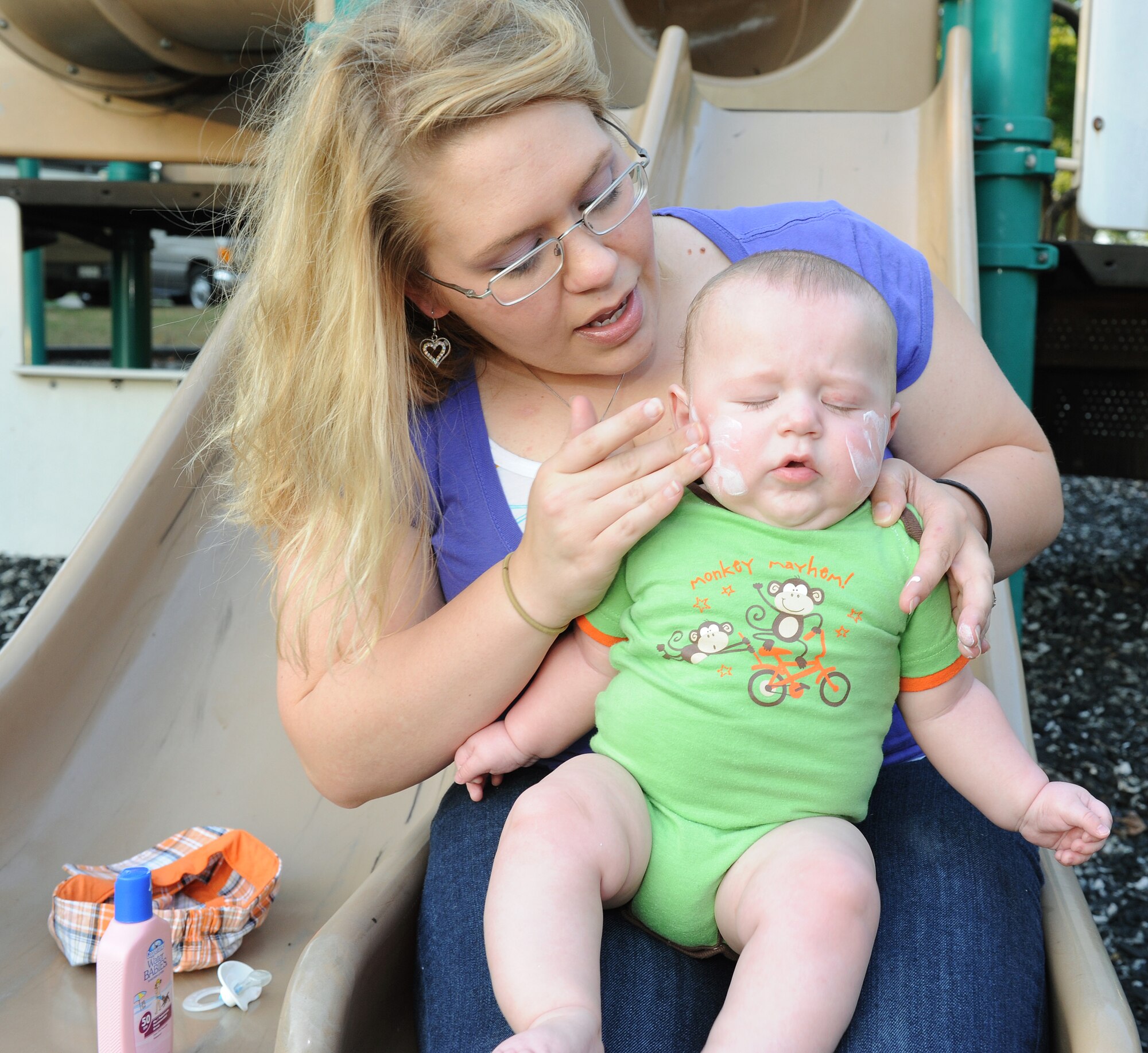 Airman 1st Class Arielle Wilson, a 19th Comptroller Squadron finance services technician, smears sunscreen on her son, Bryce, Aug. 6, 2011, at Little Rock Air Force Base, Ark. Wing safety officials say the environmental protection agency recommends using SPF 15 sunscreen for minimum protection and SPF 30 for double protection and to also wear protective clothing during the hot parts of the day. (U.S. Air Force photo by Airman 1st Class Ellora Remington)