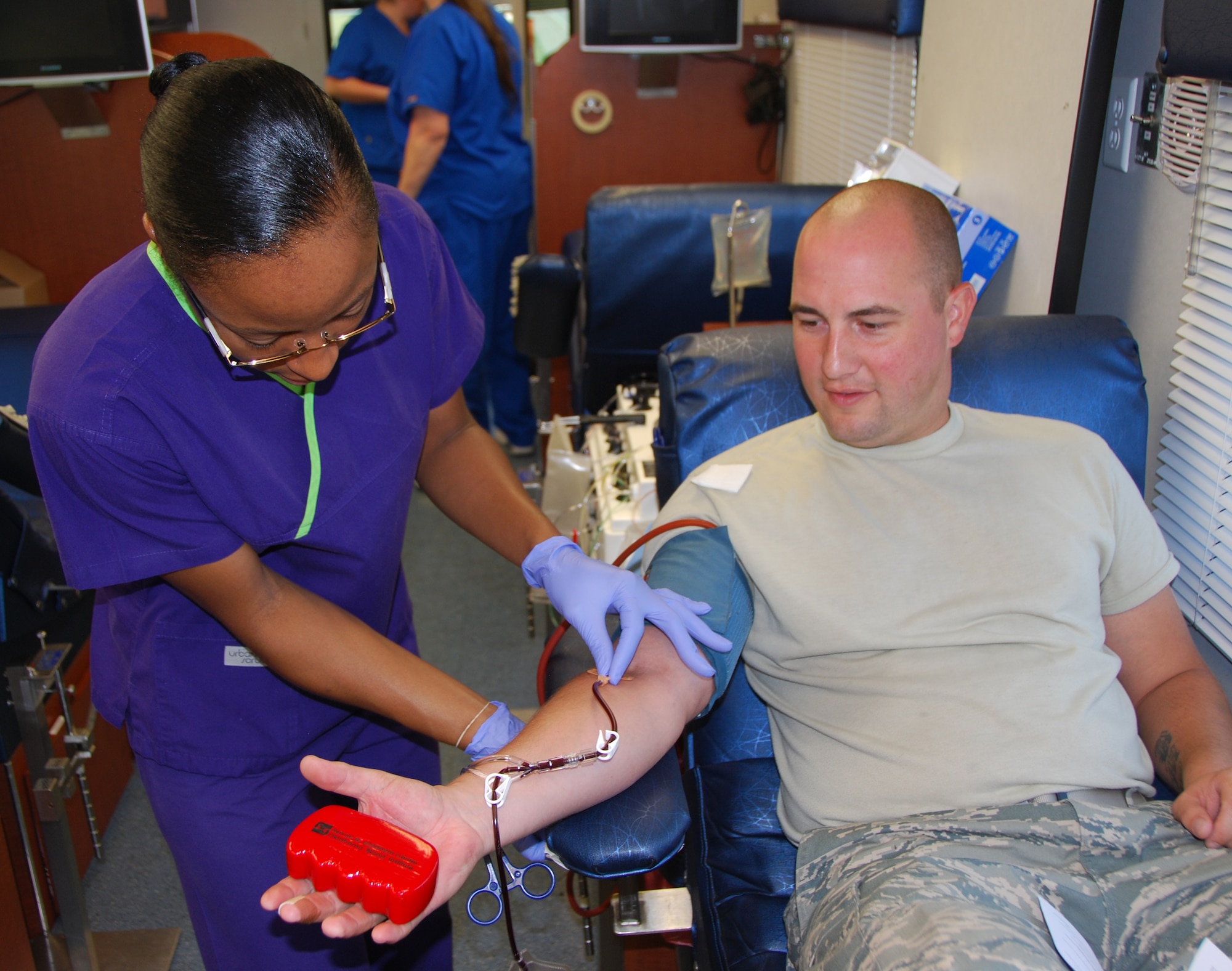 Crystal Hogg (left) adjusts the IV tube on Senior Airman Brandon Williams? arm while he donates red blood cells at an Oklahoma Blood Institute mobile blood drive at Tinker Air Force Base, Okla., on July 20, 2011. The blood goes to an apheresis machine, which separates red blood cells from his blood, then returns the plasma and platelets back to his body.  (U.S. Air Force photo by Tech. Sgt. Zach Jacobs / 110720-F-SA253-001)
