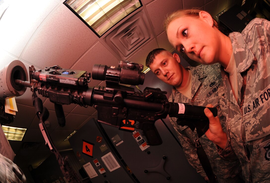 Tech. Sgt. Jason Bowers, 633rd Air Base Wing weapons safety manager, observes as Senior Airman Edith Sexton, 633rd Security Forces Squadron flight armor, clears an M-4 Carbine at Langley Air Force Base, Va., July 26, 2011. The safety office helps identify hazards and measure compliance by performing a variety of workplace inspections.  (U.S. Air Force photo by Airman 1st Class Racheal Watson/Released)