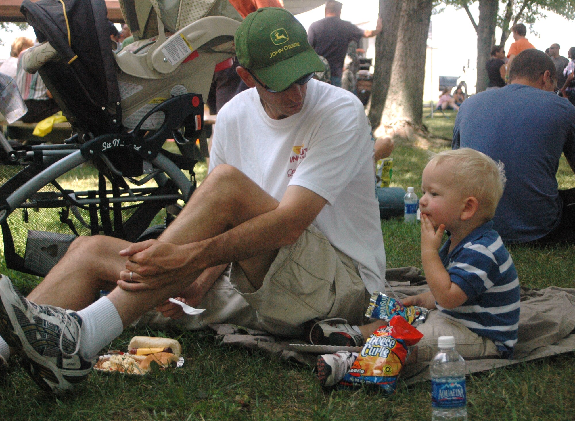 Master Sgt. Kenneth Bungarz, 512th Civil Engineering Squadron, and his son Kenneth Bungarz III, 2, eat lunch at the 512th Airlift Wing biennial picnic Aug. 6 at Eagle?s Nest. More than 2,000 people attended the event that featured live entertainment, a Kids Zone, and hamburgers, hot dogs and ice cream. (U.S. Air Force photo by Master Sgt. Veronica Aceveda)