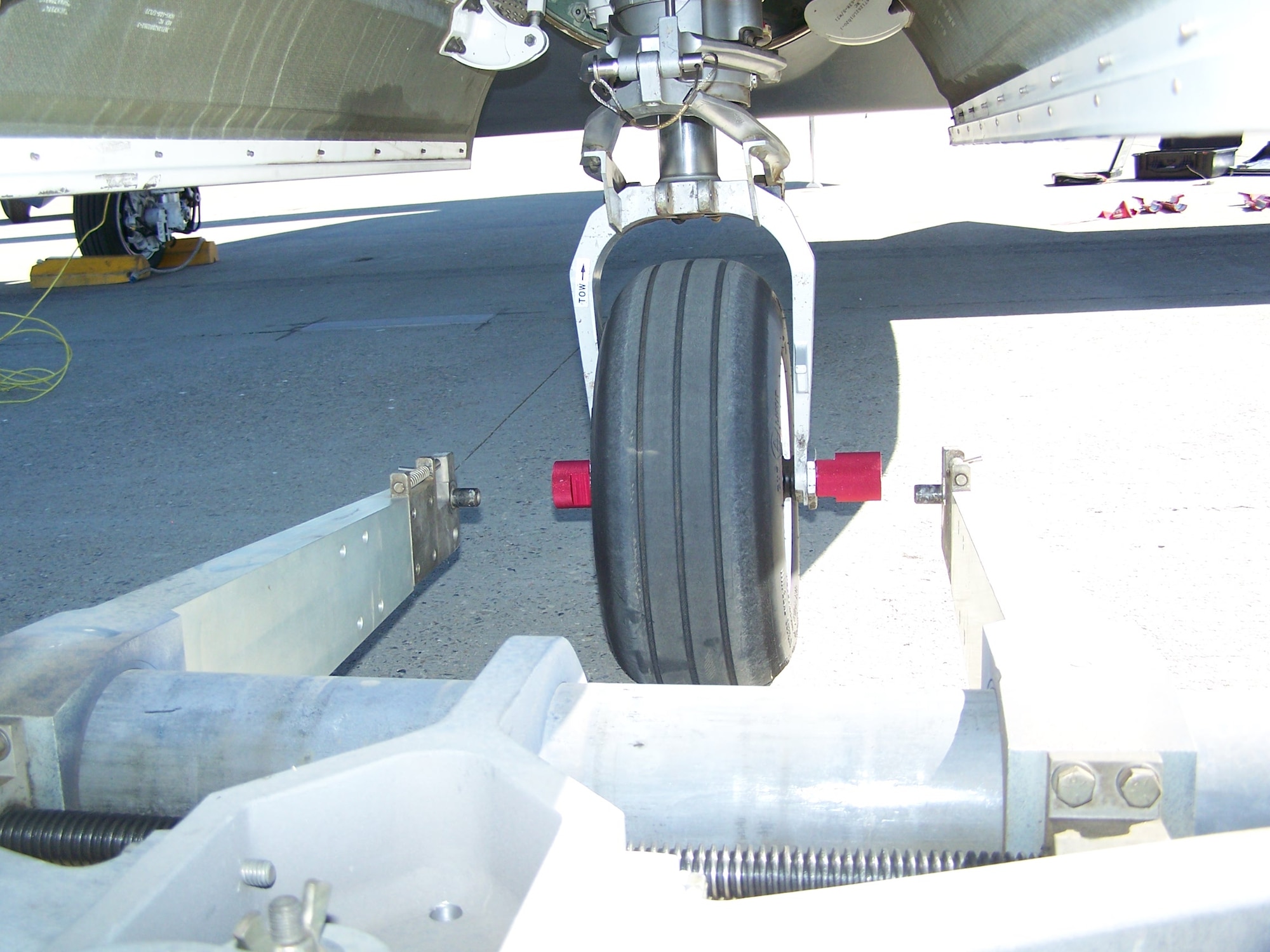 Once attached to the front wheel, the tow bar adapter (red) allows the Global Hawk to be towed by any of the universally available tow bars found at airports worldwide.  