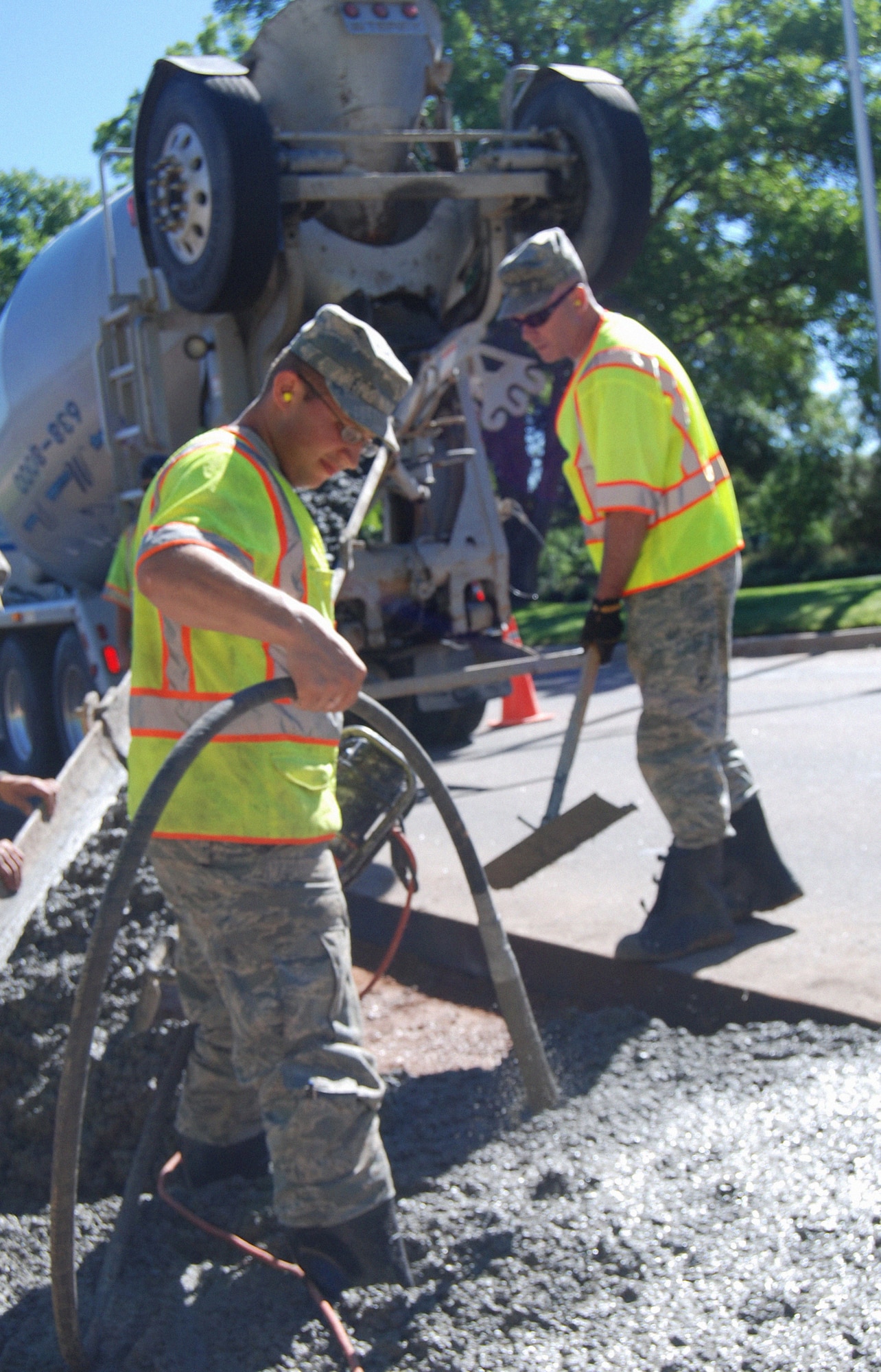 PETERSON AIR FORCE BASE, Colo. – Airman 1st Class Jose Medrano Amaya (left), 21st Civil Engineer Squadron’s heavy repair technician, helps pour concrete as Chief Master Sgt. James Byrnes (right), 21st Mission Support Group superintendent, smoothes the wet mixture. Amaya was one of many “Dirt Boyz” laboring in the heat to improve the turn lane to the clinic Aug. 5, 2011. (U.S. Air Force photo/Tech. Sgt. Amanda Callahan)