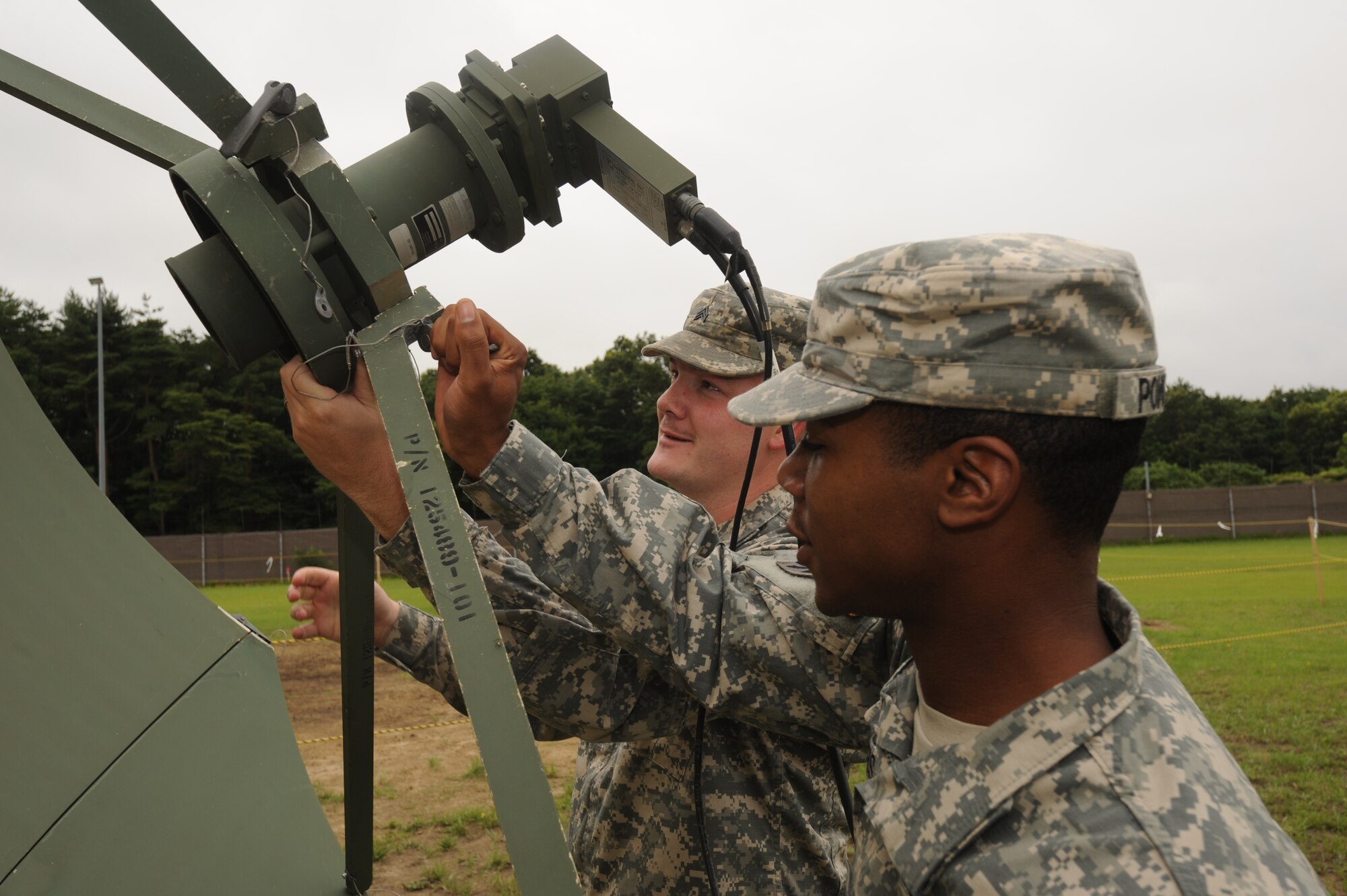 MISAWA AIR BASE, Japan -- U.S. Army Sergeants Ryon Powers, front, and Robert Hixenbaugh, Joint Tactical Ground Station Delta Detachment, 1st Space Company, adjust a low-noise amplifier on a TACSTAR II antenna Aug. 2.  The TACSTAR antenna allows for units to process missile warning data from Defense Support Program Satellites.  (U.S. Air Force photo/Staff Sgt. April Quintanilla)