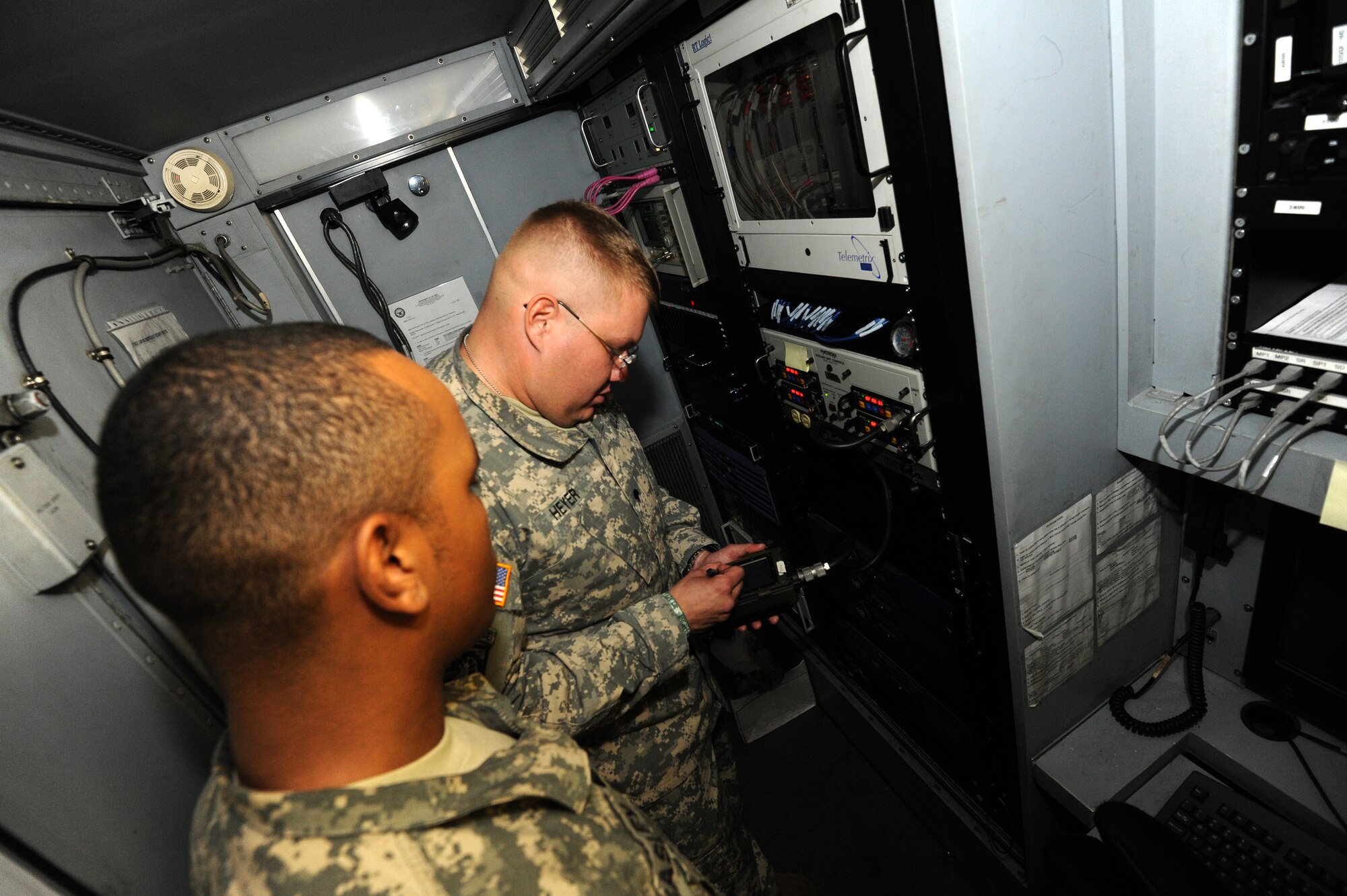 MISAWA AIR BASE, Japan -- U.S. Army Sergeant Vyncent Beasley, left, verifies transfer of satellite communication data as U.S. Army Specialist Hans Heyer loads secure communications into the Joint Tactical Ground Station system Aug. 2.  Both soldiers are members of the Joint Tactical Ground Station Delta Detachment, 1st Space Company.  (U.S. Air Force photo/Staff Sgt. April Quintanilla)