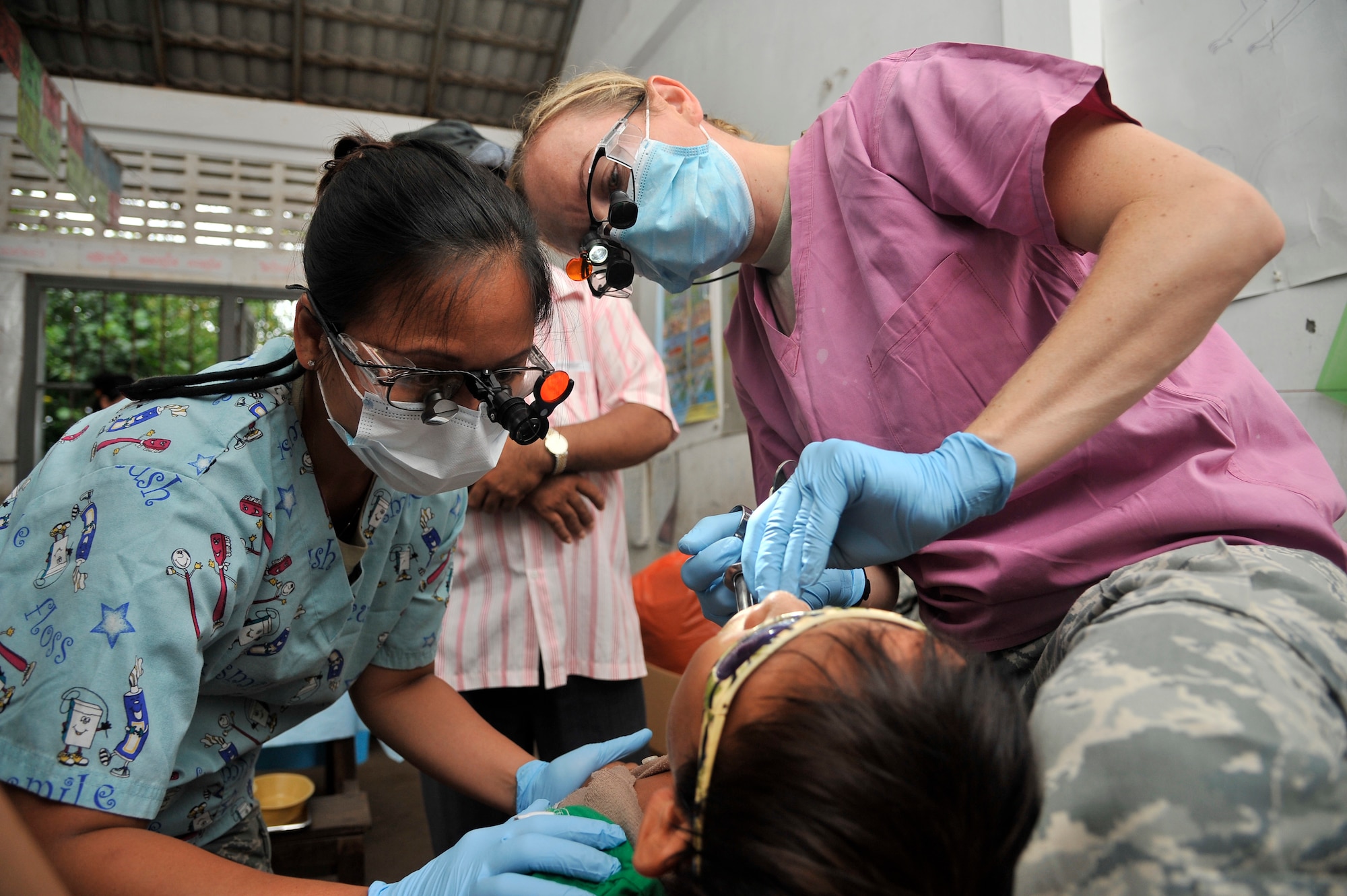 BAK KLARNG, Cambodia -- Capt. Meghan Vanderheiden and Tech. Sgt. Anabel Parks numb a patient before performing a dental procedure during Operation PACIFIC ANGEL 11-1 Aug. 8, 2011, Bak Klarng, Cambodia. The operation supports U.S. Pacific Command’s capacity-building efforts by partnering with other governments in the region to provide medical, dental, optometry and engineer assistance to their citizens. Captain Vanderheiden is a dentist and Sergeant Parks is a hygienist; both are assigned to the 35th Dental Squadron, Misawa Air Base, Japan. (U.S. Air Force photo/Staff Sgt. Christopher Boitz)