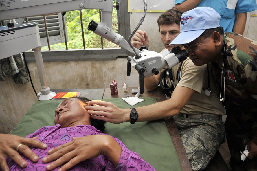 BAK KLARNG, Cambodia -- Maj. Nathaniel Duff and Capt. Sok Heng examine the ear of a Cambodian woman during Operation PACIFIC ANGEL 11-1 Aug. 8, 2011, Bak Klarng, Cambodia. The operation supports U.S. Pacific Command’s capacity-building efforts by partnering with other governments in the region to provide medical, dental, optometry and engineer assistance to their citizens. Major Duff is an ear, nose and throat surgeon assigned to the 154th Medical Group, Hawaii Air National Guard. Captain Heng is a medic in the Royal Cambodian Air Force. (U.S. Air Force photo/Staff Sgt. Christopher Boitz)