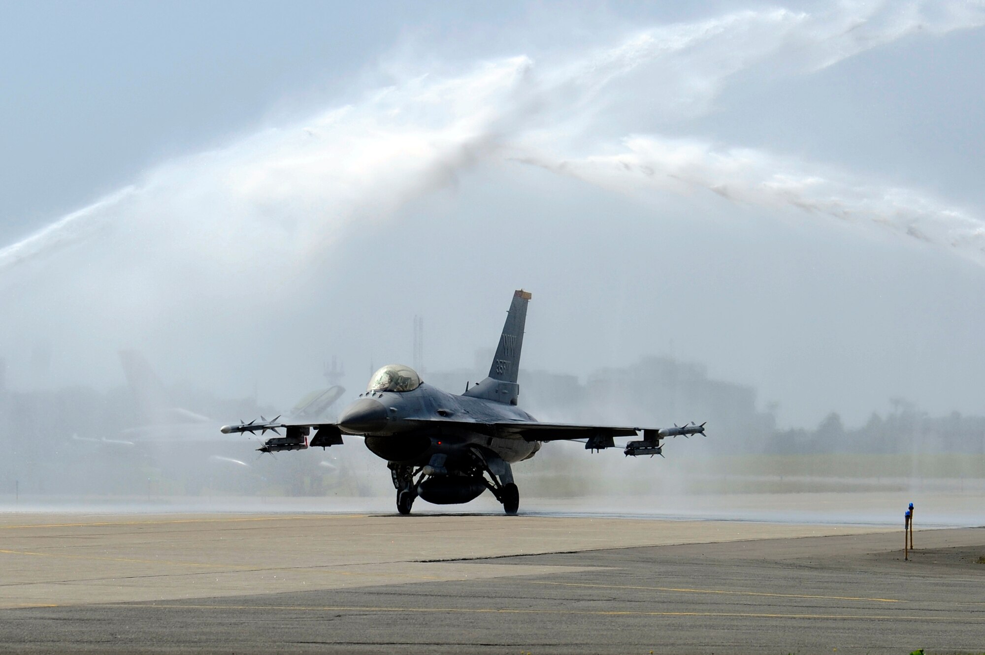 MISAWA AIR BASE, Japan -- Col. John Pearse, 35th Operations Group commander, taxis under jets of water on Misawa's runway in an F-16 Fighting Falcon after his "fini-flight" Aug. 5. Following his change of command ceremony Sept. 6, Colonel Pearse will leave Misawa and be assigned to Air Combat Command and work with the Inspector General at Langley Air Force Base, Va. (U.S. Air Force photo/Tech. Sgt. Marie Brown/Released)