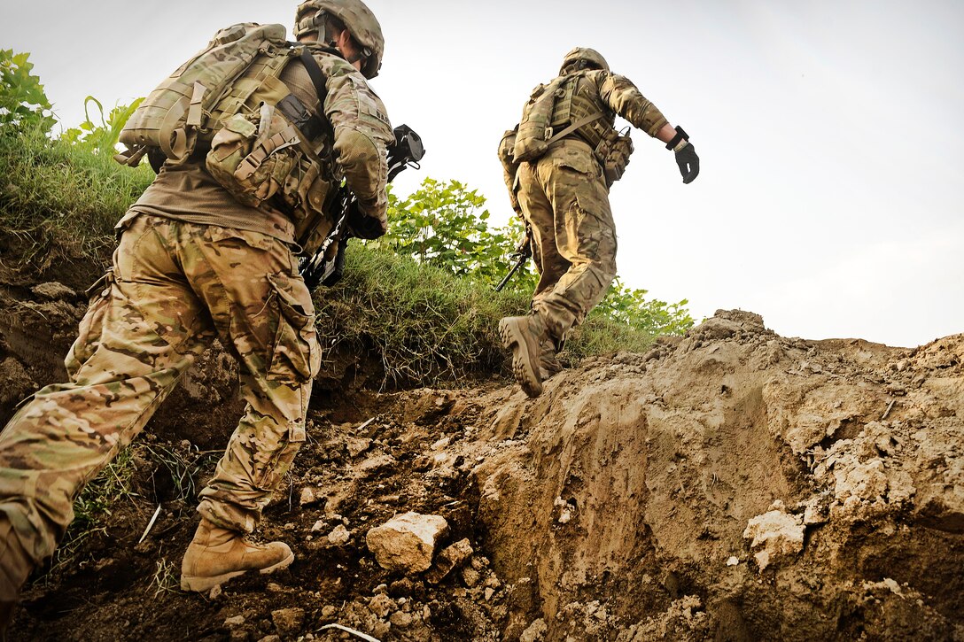 U.S. Army Staff Sgt. Michael Duffy and Spc. Michael Bartolo navigate through rice paddies and corn fields while on a combat patrol to sweep for roadside bomb triggermen in the Alingar district in Afghanistan's Laghman province, Aug. 7, 2011. Duffy and Bartolo are assigned to the Laghman Provincial Reconstruction Team.