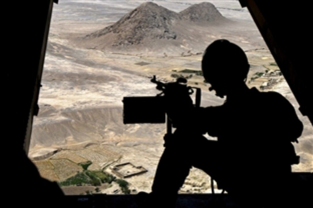 A U.S. Marine MV-22 Osprey aircrew member scans the terrain during a mission supporting U.S. Marine Corps Gen. John R. Allen, commander of U.S. and international forces in Afghanistan, in Helmand province, Afghanistan, Aug. 4, 2011.