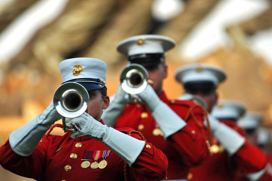 Marines with the U.S. Marine Drum and Bugle Corps play their bugles while marching during a Tuesday Sunset Parade at the Marine Corps War Memorial in Arlington, Va., Aug. 9, 2011.