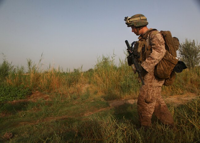 Hospital Apprentice Jesse Stephens, a native of Hartselle, Al., patrols through the Polpazai village, here  Aug. 11. The 19-year old Stephens, serves as a Navy corpsman with, 2nd Squad, 4th Platoon, Charlie Company, 1st Battalion, 6th Marine Regiment, and is on his first deployment.