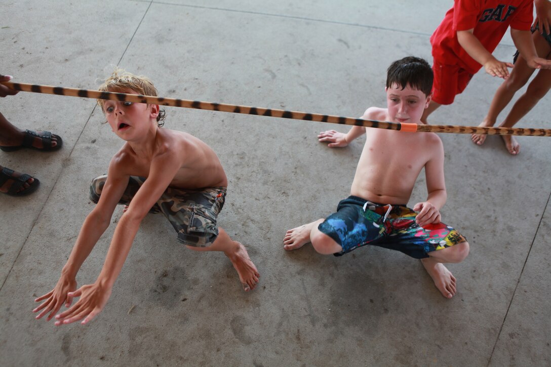 Two children compete in a limbo contest at Marine Corps Base Camp Lejeune’s Onslow Beach, Aug. 9. The 24th Marine Expeditionary Unit Marines, Sailors and their families took a day off work to relax on the beach and build unit cohesion.