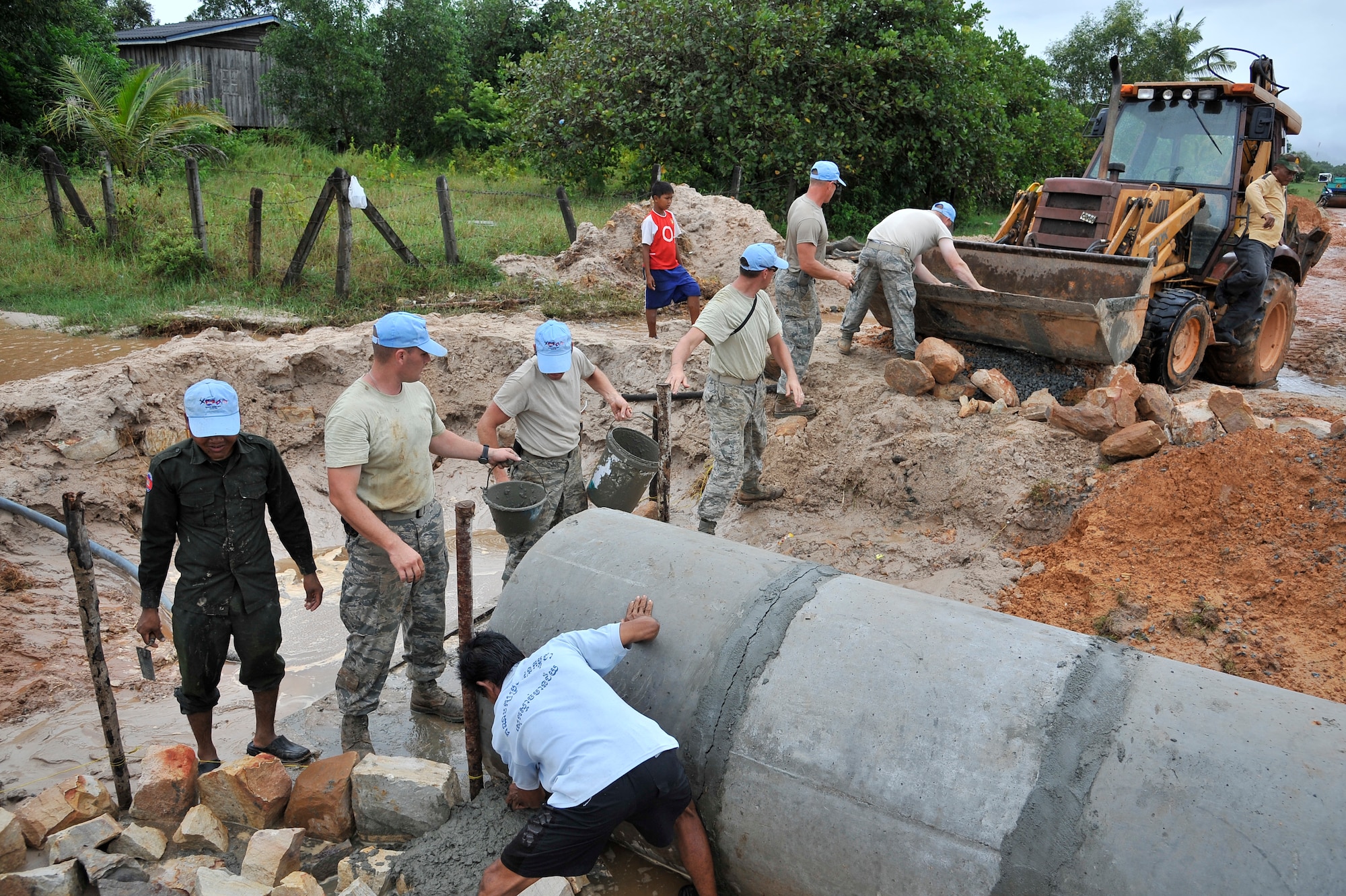 KOH KONG, Cambodia – U.S. Air Force civil engineers and Royal Cambodian Armed Forces engineers pass buckets of cement to form a dam along a culvert here during PACIFIC ANGEL 11-1 Aug. 10, 2011. PA 11-1 partners U.S. and Cambodian military and civilian personnel to provide medical, dental, optometry and engineer programs to local Cambodians as well as airfield operations subject-matter expert exchanges. The culvert will improving water flow which has closed access to a local clinic. (U.S. Air Force photo/Staff Sgt. Christopher Boitz)