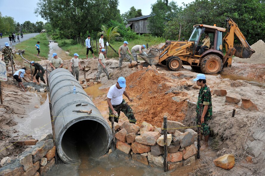 KOH KONG, Cambodia – U.S. Air Force civil engineers and Royal Cambodian Armed Forces engineers put a new culvert in a road here during PACIFIC ANGEL 11-1 Aug. 10, 2011. PA 11-1 partners U.S. and Cambodian military and civilian personnel to provide medical, dental, optometry and engineer programs to local Cambodians as well as airfield operations subject-matter expert exchanges. The culvert will improving water flow which has closed access to a local clinic. (U.S. Air Force photo/Staff Sgt. Christopher Boitz)

