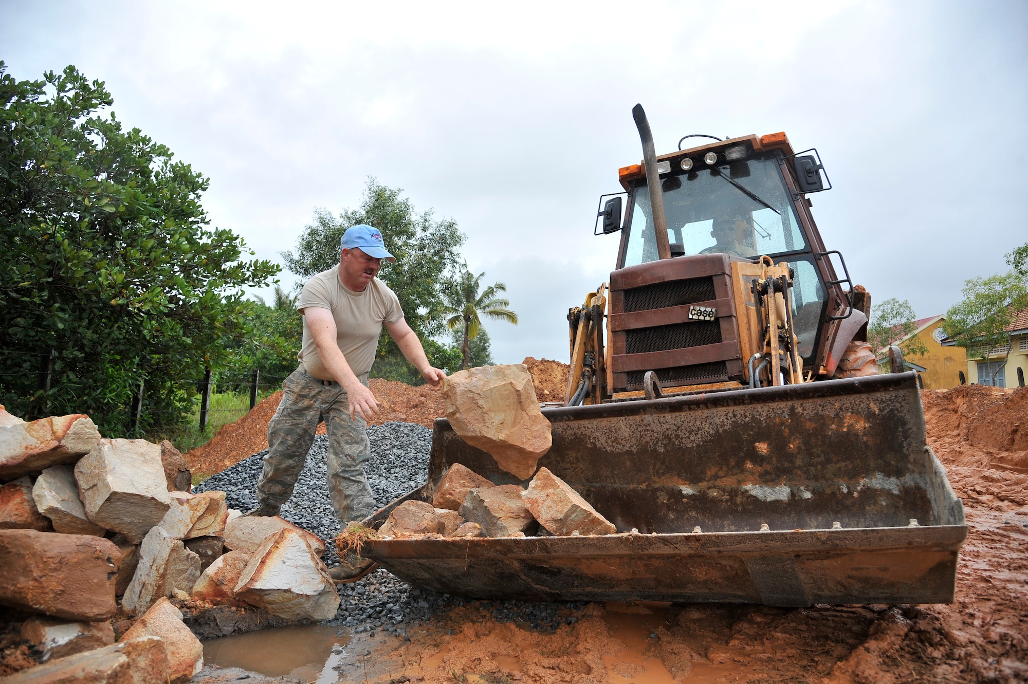 KOH KONG, Cambodia – Staff Sgt. Tracy Hostetler throws boulders in a backhoe here during PACIFIC ANGEL 11-1 Aug. 10, 2011. PA 11-1 partners U.S. and Cambodian military and civilian personnel to provide medical, dental, optometry and engineer programs to local Cambodians as well as airfield operations subject-matter expert exchanges. Sergeant Hostetler is an equipment and paving technician assigned to the 124th Civil Engineer Squadron, Boise, Idaho. (U.S. Air Force photo/Staff Sgt. Christopher Boitz)