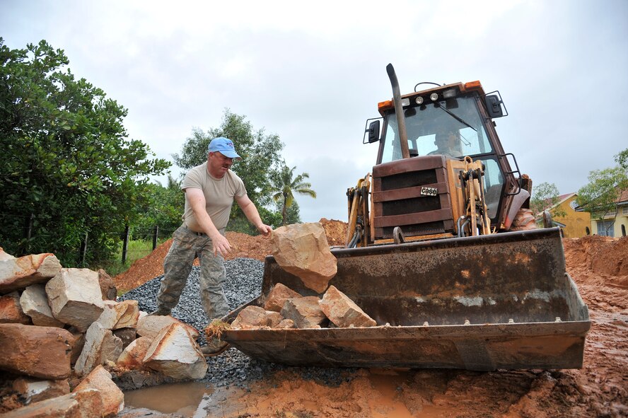KOH KONG, Cambodia – Staff Sgt. Tracy Hostetler throws boulders in a backhoe here during PACIFIC ANGEL 11-1 Aug. 10, 2011. PA 11-1 partners U.S. and Cambodian military and civilian personnel to provide medical, dental, optometry and engineer programs to local Cambodians as well as airfield operations subject-matter expert exchanges. Sergeant Hostetler is an equipment and paving technician assigned to the 124th Civil Engineer Squadron, Boise, Idaho. (U.S. Air Force photo/Staff Sgt. Christopher Boitz)