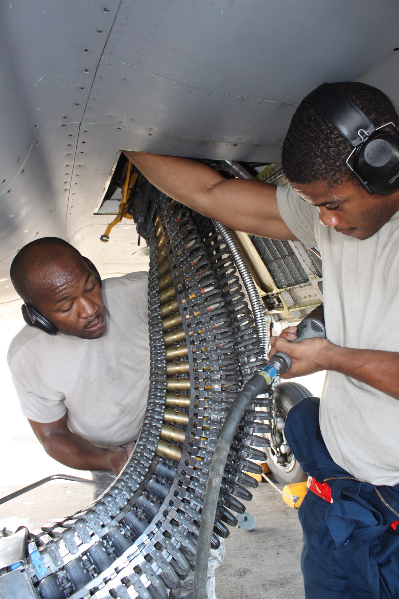 Staff Sgt. Marcus Wilson (left) and Airman 1st Class Vertram George (right), both from the 67th Aircraft Maintenance Unit, upload rounds into an F-15 gun drum during Beverly High 11-6, a Local Operational Readiness Exercise on Kadena Air Base, Japan, Aug. 10. The LORE allows Kadena Airmen to sharpen skills needed during normal and contingency operations. (U.S. Air Force photo/Maj. John Jacobus)