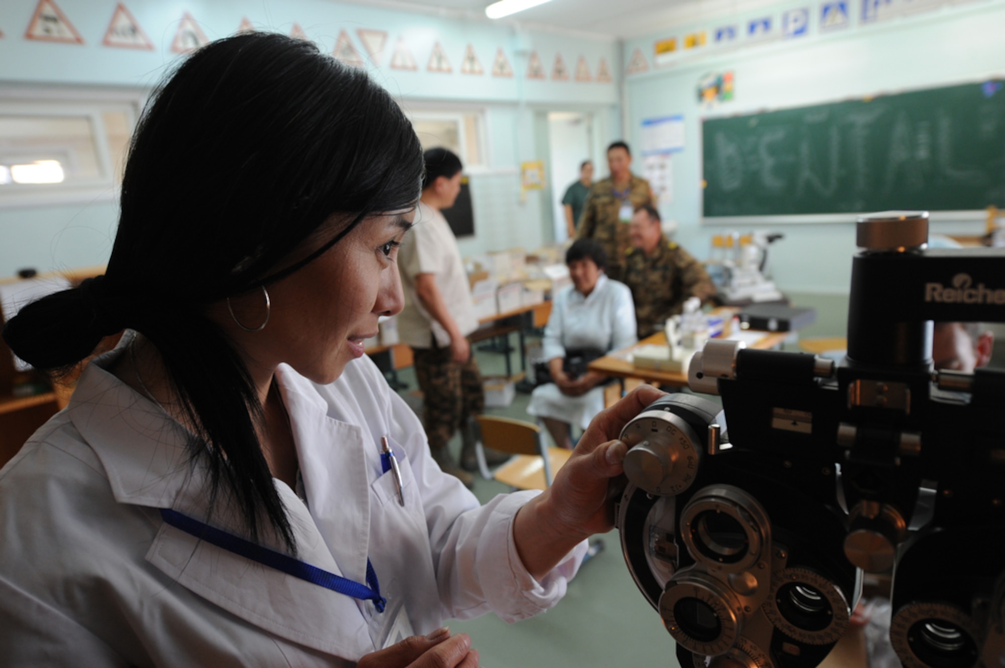 Mongolian Ophthalmologist Mirankhjin Naasantser prepares to test the eyesight of a patient during a consultation at the Buynt Uhaa Complex in Ulaanbaatar, Mongolia on Aug. 9 during Khaan Quest 2011, a combined joint-exercise hosted by the Mongolian Armed Forces in partnership with U.S. Pacific Command forces. Medical Civil Action Programs like this enable the countries involved to become familiar with one another in addition to helping the community of the host country.  Khaan Quest officially started July 31 and continues until Aug 12. (U.S.  Air Force photo/Master Sgt. Cohen A. Young)