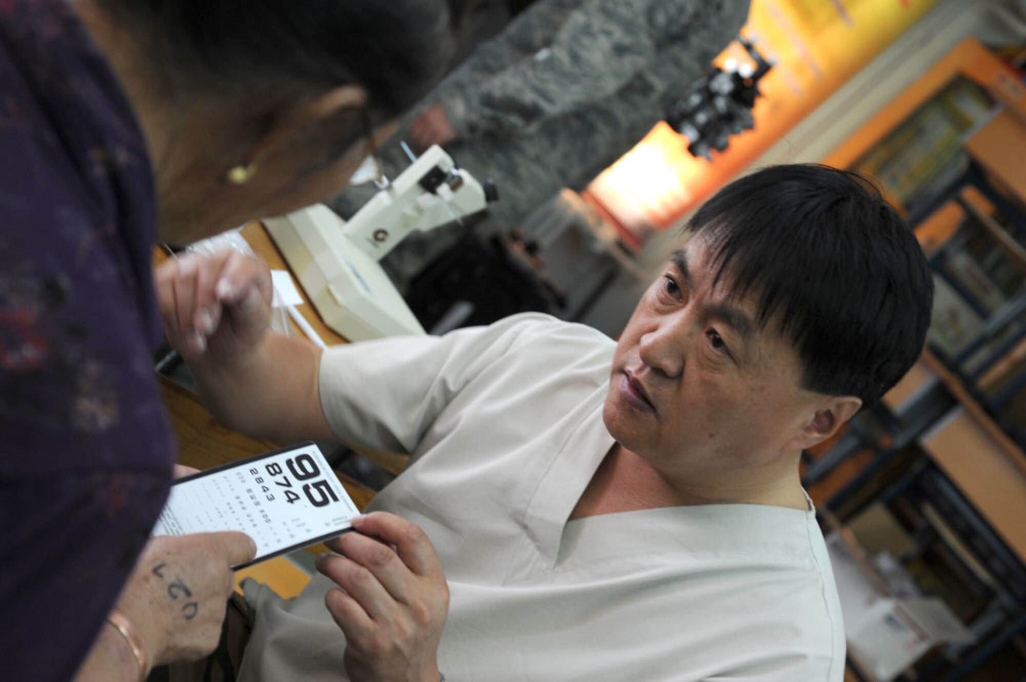 ULAANBAATAR, Mongolia – Mongolian Armed Forces Lt. Col Elbegjargal Buyantogtoich administers a quick eye adjustment test after fitting a Mongolian woman with a new set of glasses during a consultation at the Buynt Uhaa Complex in Ulaanbaatar, Mongolia on Aug. 9 during Khaan Quest 2011, a combined joint-exercise hosted by the Mongolian Armed Forces in partnership with U.S. Pacific Command forces. Medical Civil Action Programs like this enable the countries involved to become familiar with one another in addition to helping the community of the host country.  Khaan Quest officially started July 31 and continues until Aug 12. (U.S.  Air Force photo/Master Sgt. Cohen A. Young)