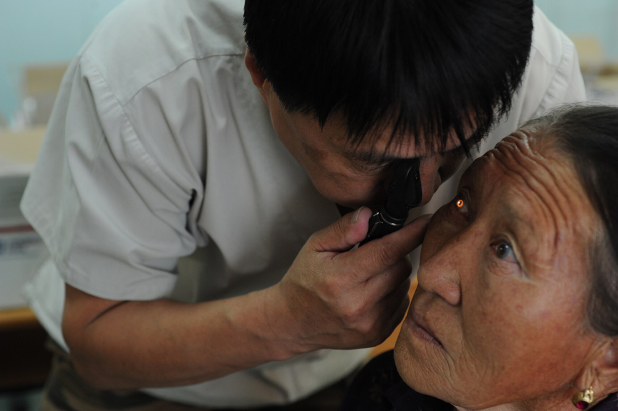 ULAANBAATAR, Mongolia ? Mongolian Armed Forces Lt. Col Elbegjargal Buyantogtoich examines the cornea of an elderly Mongolian woman during a consultation at the Buynt Uhaa Complex in Ulaanbaatar, Mongolia on Aug. 9 during Khaan Quest 2011, a combined joint-exercise hosted by the Mongolian Armed Forces in partnership with U.S. Pacific Command forces. Medical Civil Action Programs like this enable the countries involved to become familiar with one another in addition to helping the community of the host country.  Khaan Quest officially started July 31 and continues until Aug 12. (U.S.  Air Force photo/Master Sgt. Cohen A. Young)