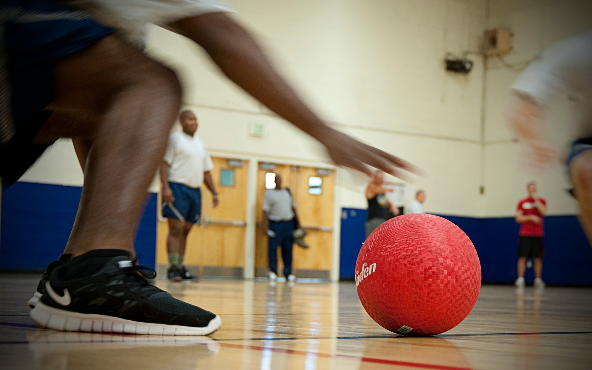 A member of the 403rd Wing reaches forward to pick up a dodge ball at the start of the Wing's dodge ball tournament Aug. 6. The event was held as part of the Human Resource Development Council's quarterly fitness challenge.  The 403rd Operations Group defeated the 403rd Logistics Squadron in the finals. (U.S. Air Force Photo by Staff Sgt. Brent Skeen)
