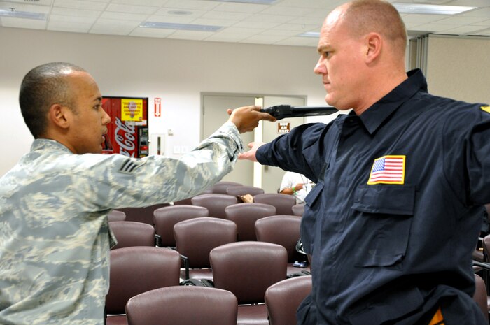 Senior Airman Cedric Brunson, 99th Logistics Readiness Squadron passenger terminal operations technician, screens a member of the Federal Emergency Management Agency Nevada Urban Search and Rescue Task Force One July 20, 2011, inside the 99 LRS Deployment Center. FEMA and the Air Force jointly conducted an exercise to simulate recalling the Nevada Task Force for a disaster or emergency and preparing FEMA personnel and equipment to fly aboard a military aircraft. (U.S. Air Force photo by 2nd Lt. Ken Lustig/Released)